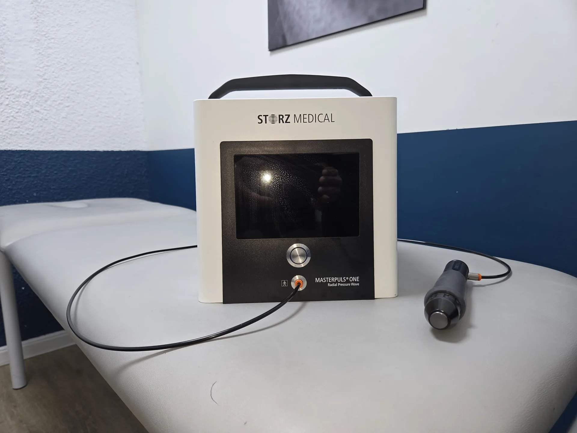 Générateur d'ondes de choc radiales et son applicateur, posés sur une table de soin